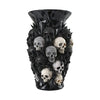 A black decorative vase shaped like a skull, featuring numerous smaller skulls.