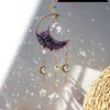 A handcrafted moon crystal suncatcher featuring a purple crescent pendant and dangling prism beads.
