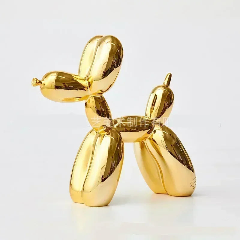 A golden resin balloon dog sculpture with a whimsical design, used as home or office decor.