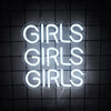 A white neon sign shaped like a cloud spelling out GIRLS, hanging against a dark grid background.