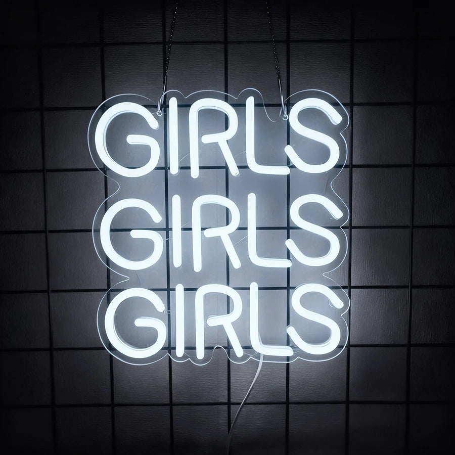 A white neon sign shaped like a cloud spelling out GIRLS, hanging against a dark grid background.