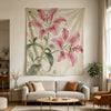 A large pink lily tapestry featuring elegant floral designs hanging on a light-colored wall.