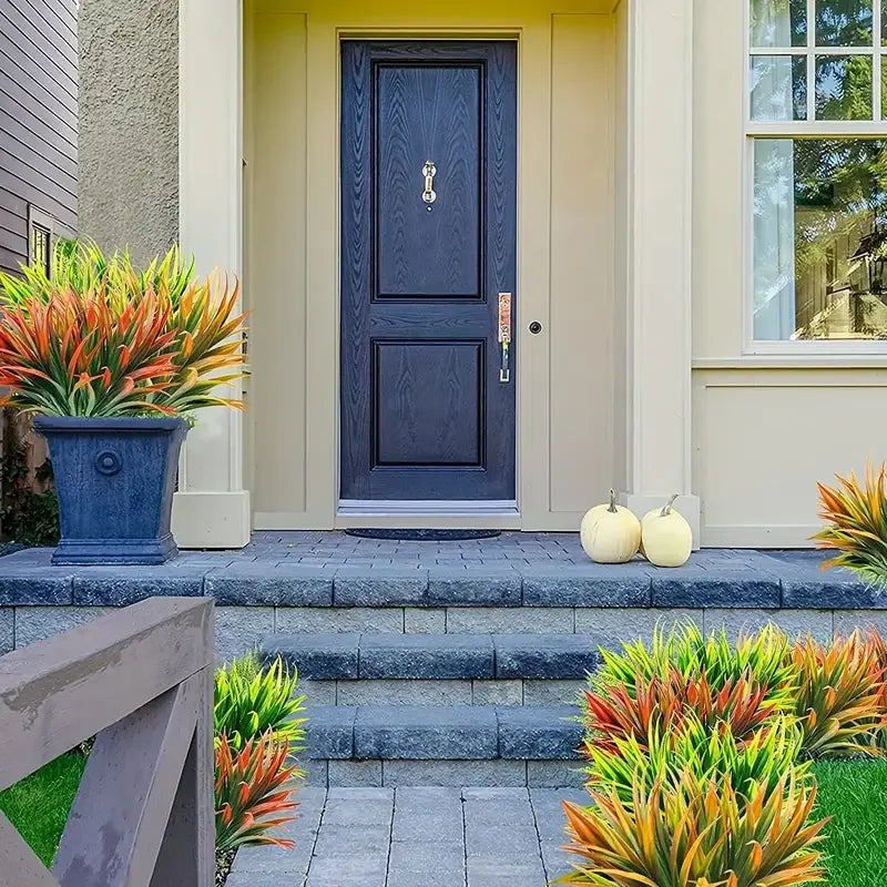 A front door with a dark blue panel and light beige trim, flanked by potted tropical plants.