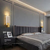 Modern bubble crystal LED wall sconces illuminating a gray upholstered bed and modern bedroom wall.