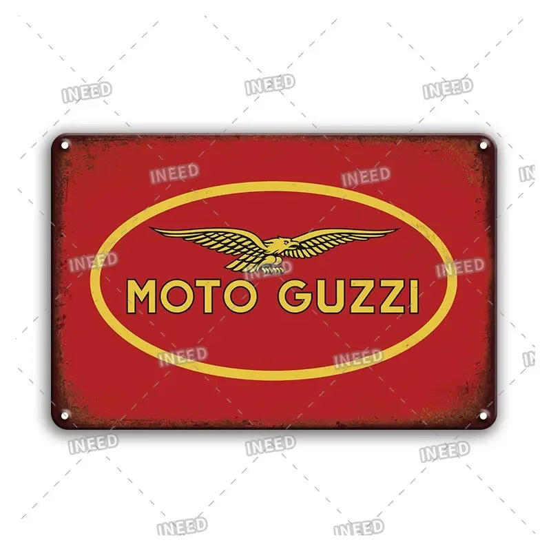 Vintage red metal sign with a yellow oval featuring a golden winged motorcycle emblem and the text MOTO GUZZI