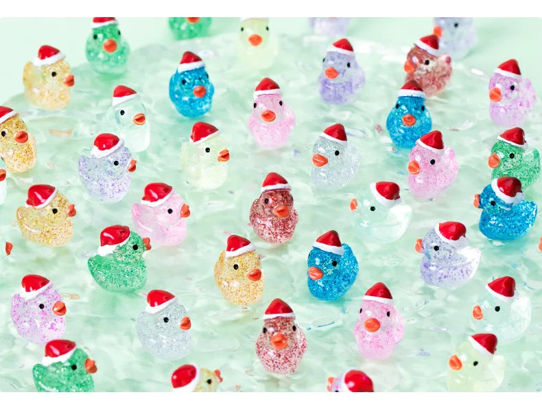 A collection of glow-in-the-dark Christmas duck figurines wearing Santa hats scattered on a clear surface.