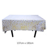 Una mesa desechable rectangular blanca cubierta con lunares dorados.