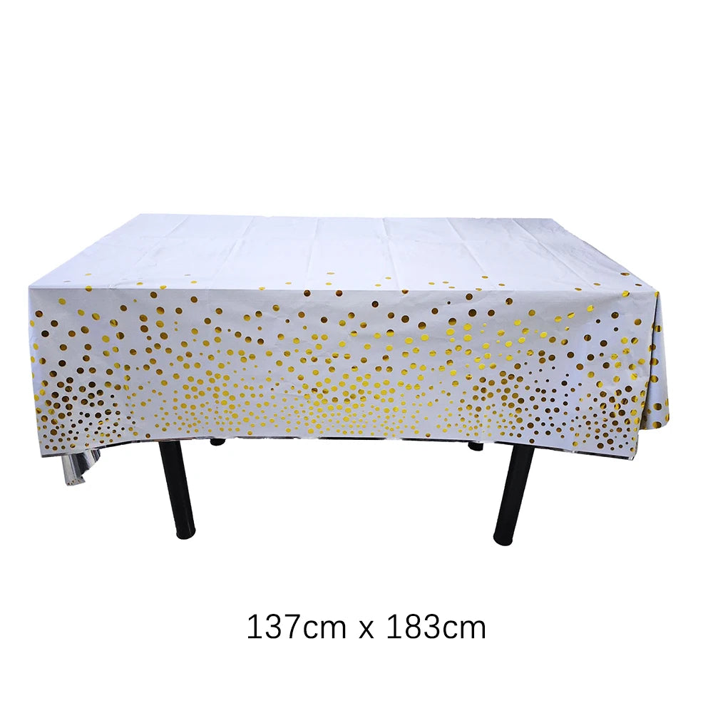 Una mesa desechable rectangular blanca cubierta con lunares dorados.