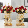 A pair of elegant ceramic swan vases with floral arrangements for modern home decor.