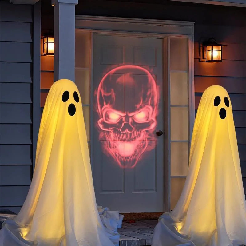 Two white ghost decorations with glowing faces are displayed in front of a white door.