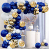 A balloon garland arch featuring navy blue, silver, gold, and white balloons displayed against a light blue curtain.