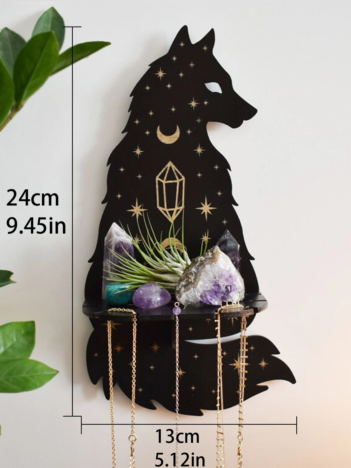 A black silhouette of a wolf head with stars, holding crystals, and a crescent moon, mounted on a floating shelf.