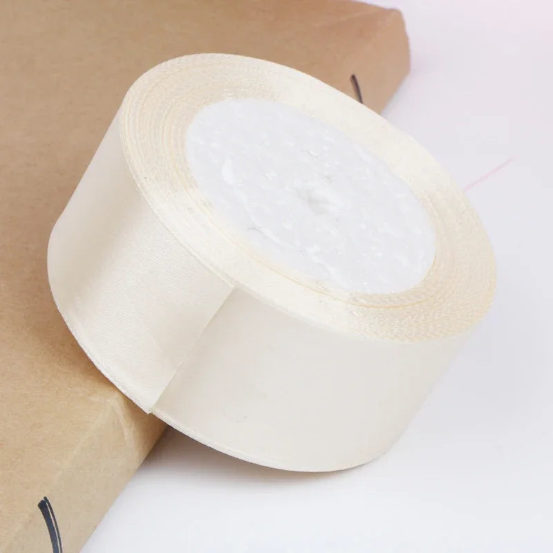 Roll of white satin ribbon for crafts and gift wrapping placed on brown paper.