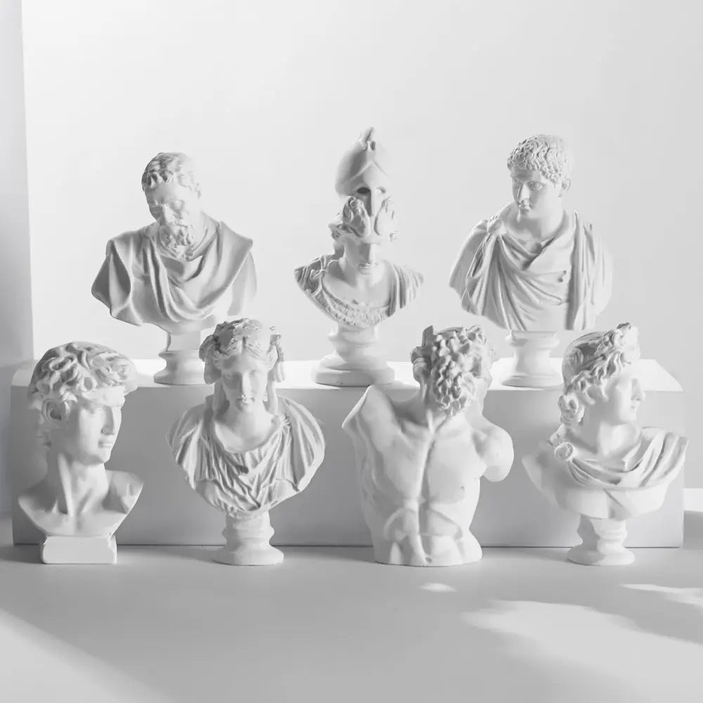A collection of plaster bust miniatures depicting figures from Greek mythology, displayed against a white background.