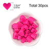 A pile of pink silicone heart beads for DIY jewelry making, with a heart shape shown for scale.