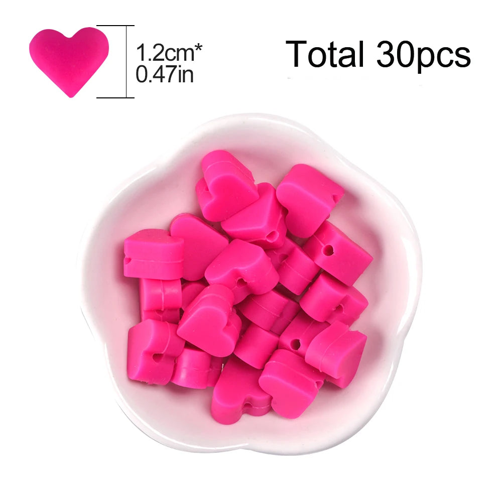 A pile of pink silicone heart beads for DIY jewelry making, with a heart shape shown for scale.