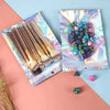 Holographic rainbow resealable bags filled with colorful beads and makeup brushes for storage