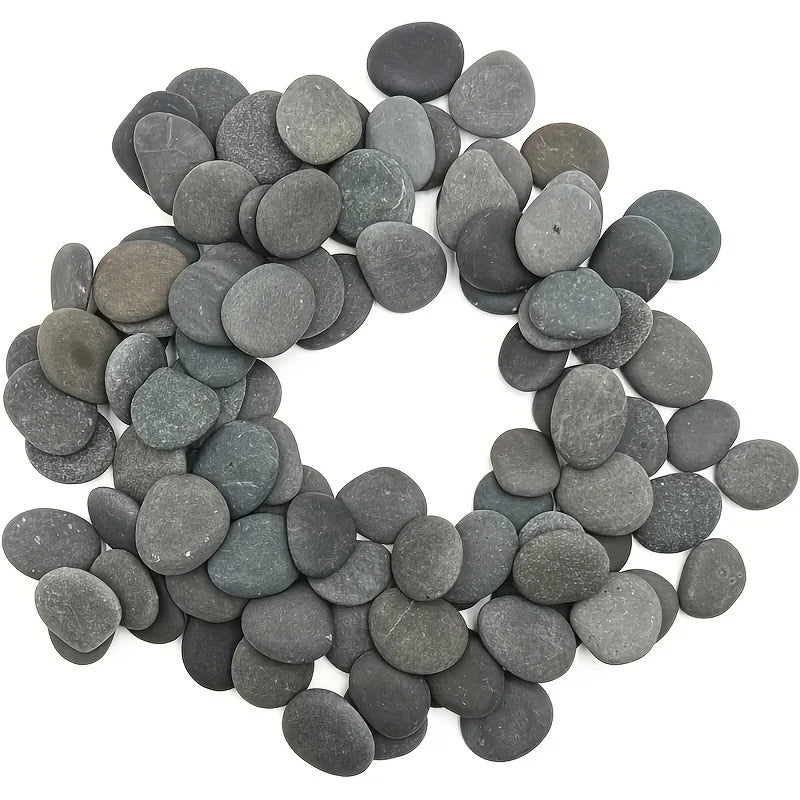 A collection of smooth, dark gray river rocks used for aquariums, art, and rock painting.