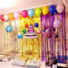 A vibrant metallic foil tinsel fringe backdrop set featuring balloons and decorative elements for a party display.