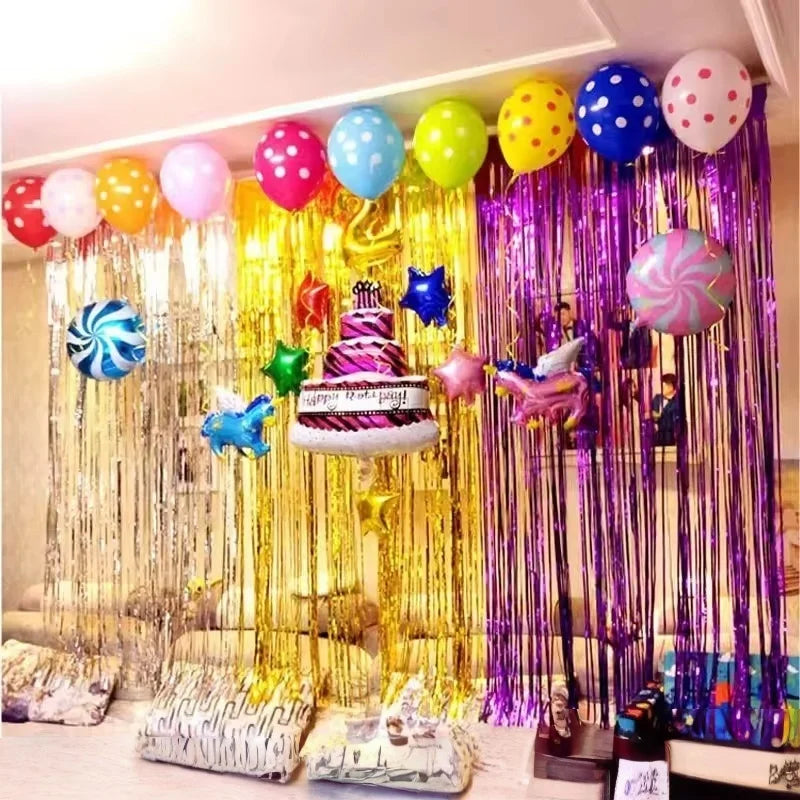 A vibrant metallic foil tinsel fringe backdrop set featuring balloons and decorative elements for a party display.