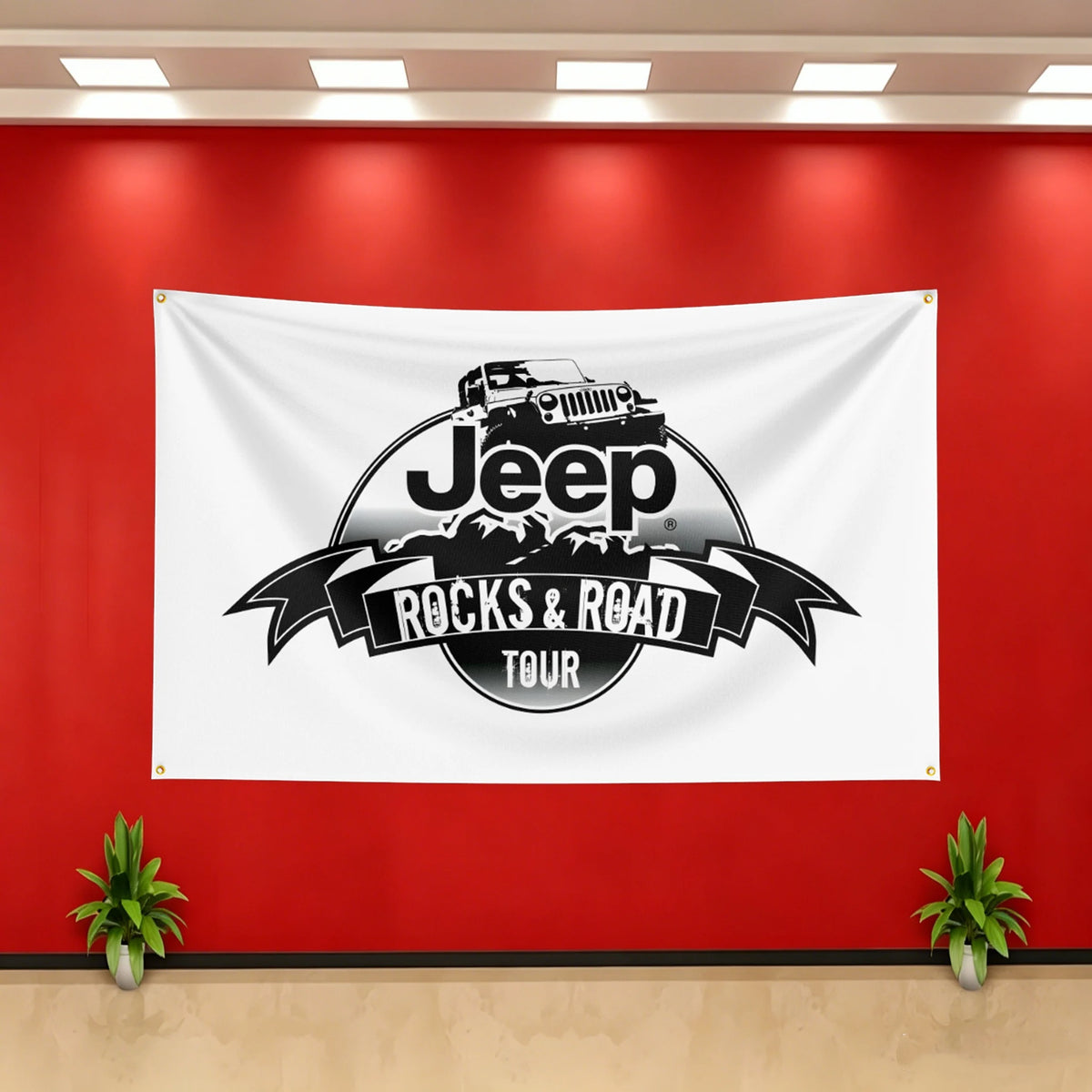 A white banner featuring a black silhouette of a Jeep with the text Rocks & Road Tour on a circular emblem.