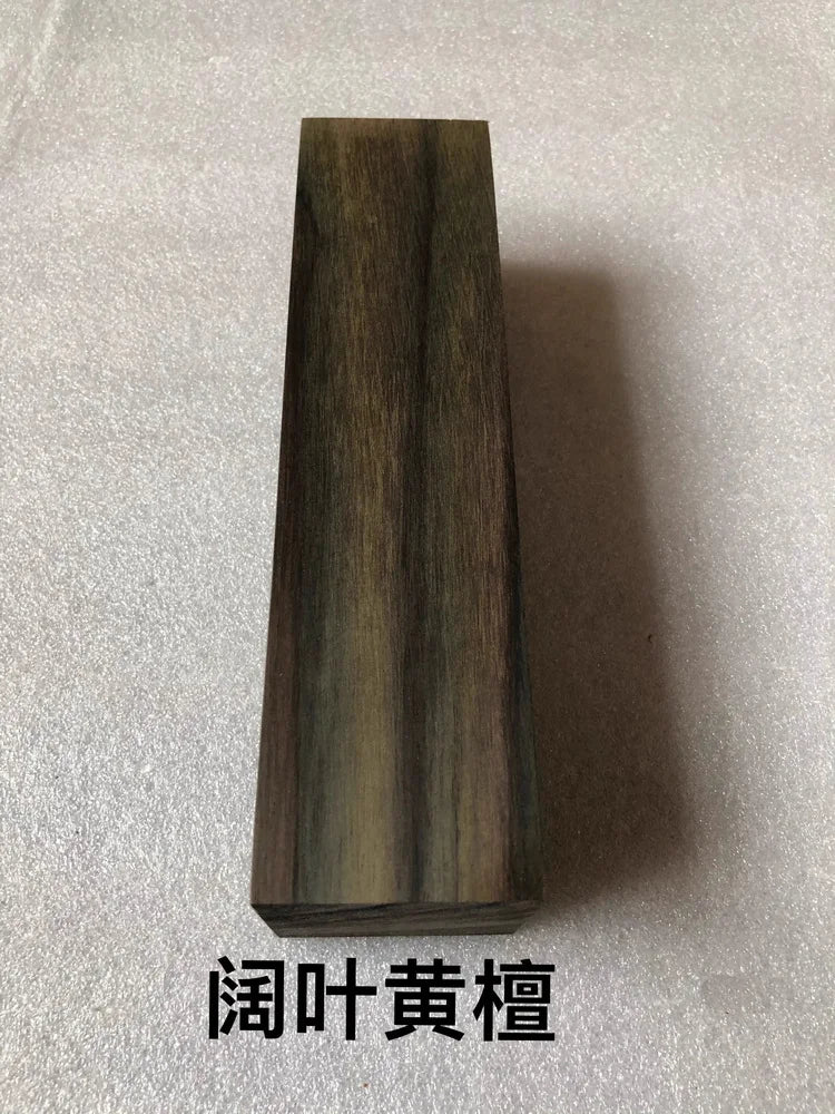 A vertical rectangular block of dark, richly grained wood used as a blank for knife handles and DIY projects.
