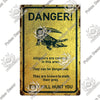 A vintage warning metal sign with a yellow background featuring an alligator illustration and the text DANGER! They can be da
