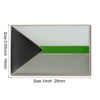 A rectangular lapel pin featuring a geometric design with black, white, and green sections.