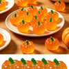 A collection of bright orange mini artificial pumpkins arranged on a white plate and wooden surface.
