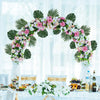 A floral arch decorated with pink and white flowers and green palm leaves for party decor