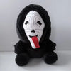 A black plush toy of Ghost Face with a white mask and a red tongue.