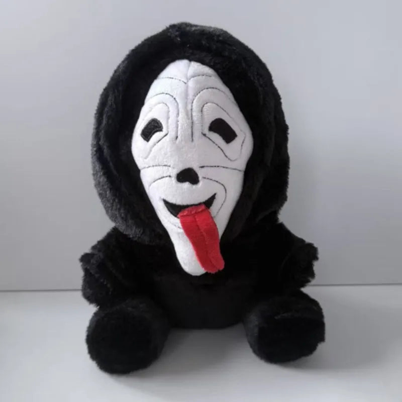 A black plush toy of Ghost Face with a white mask and a red tongue.