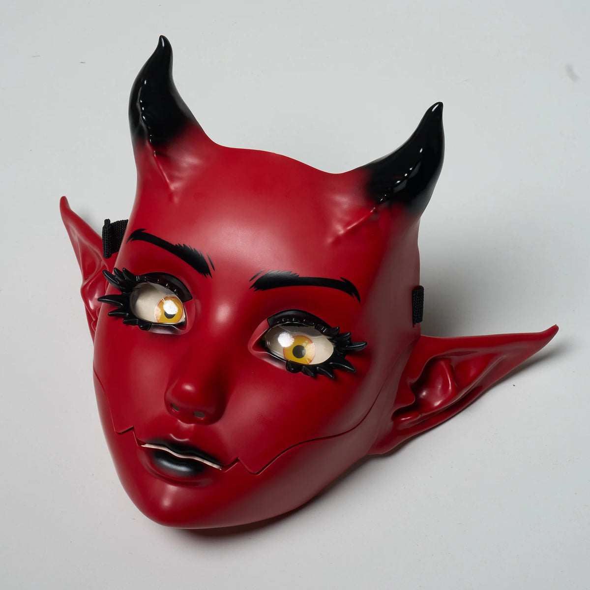 A red, horned fantasy creature mask with black accents and movable jaw.