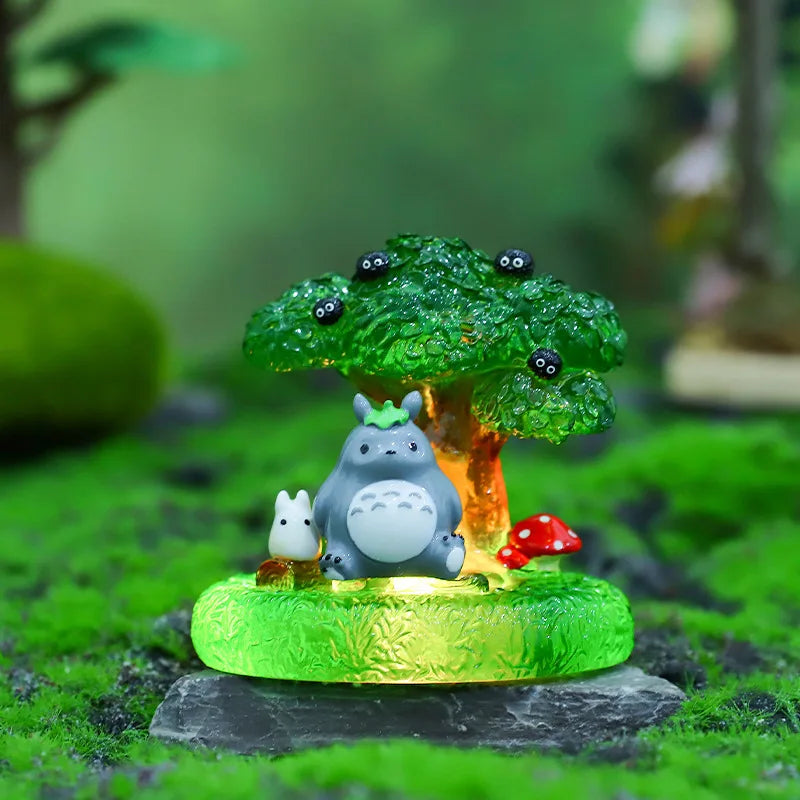 A green tree ornament featuring a small gray animal figurine on a mossy base.
