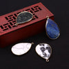 Three gemstone pendants, including a dark gray agate, a blue lapis lazuli stone, and two white marble pendants, displayed on 