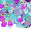 A pile of round tissue paper confetti dots in shades of purple, teal, and light gray.