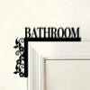 Black metal wall plaque with the word BATHROOM and a floral design on a white frame.
