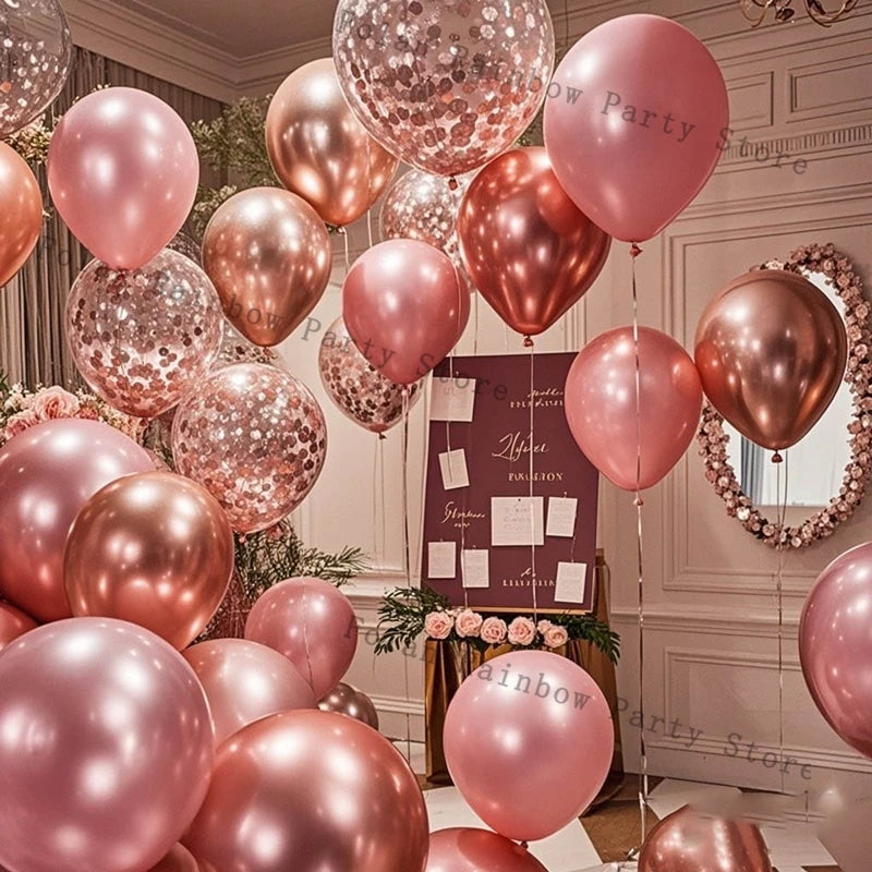 A close-up of pink and rose gold latex balloons filled with glitter confetti used for party decorations.