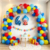 A colorful balloon arch garland for a birthday party featuring blue, yellow, and red balloons with a clown decoration.