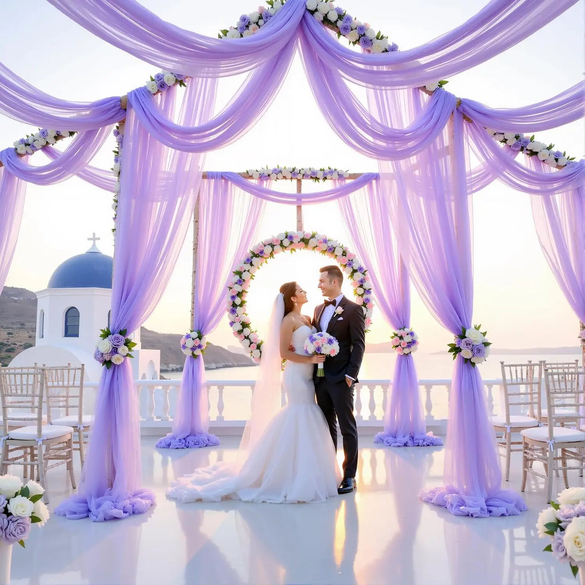 An elegant purple tulle backdrop decorated with flowers framing a couple for an event.