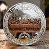 A silver commemorative coin featuring a scene of the Last Supper with Jesus and disciples, surrounded by laurel leaves and a 