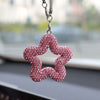 A pink rhinestone star-shaped charm hanging from a silver chain.