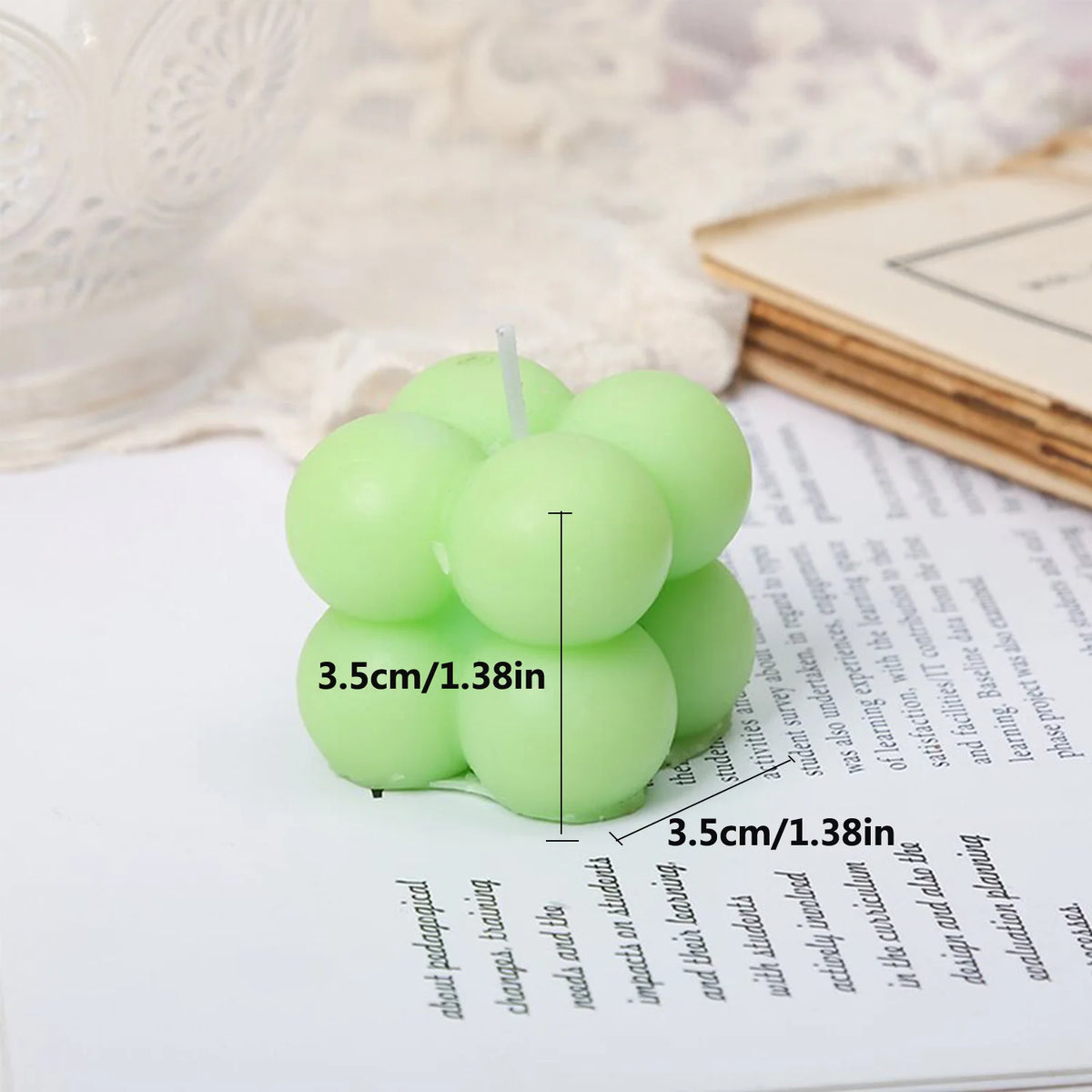 A set of two light green cube soy wax candles resting on a white surface.