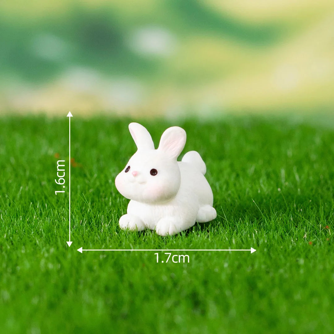 A small white rabbit figurine sitting on green grass with measurement lines.