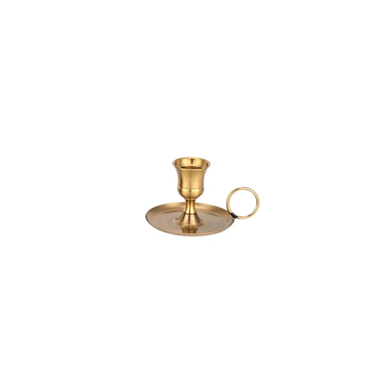 A brass metal candle holder with a flared cup and a circular handle, designed for elegant table settings.