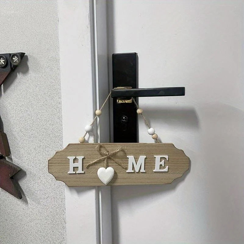 Rustic wooden door welcome sign with the word HOME carved into the wood and hung on a white door.