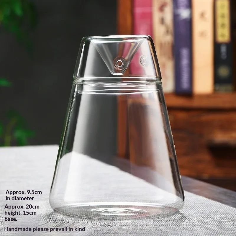 Clear glass multi-size decor vase with a pointed top sitting on a white surface.