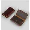 A dark brown vintage leather card holder and cable organizer shown from an angled view.