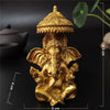 A golden bronze statue of Ganesha Buddha seated in a meditative pose, used for home decor.