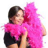 A woman holds a bright pink natural turkey feather boa for costumes and crafts.